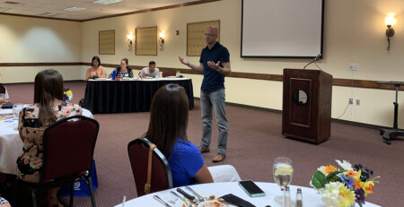 Andy Roller speaking in front of an audience.