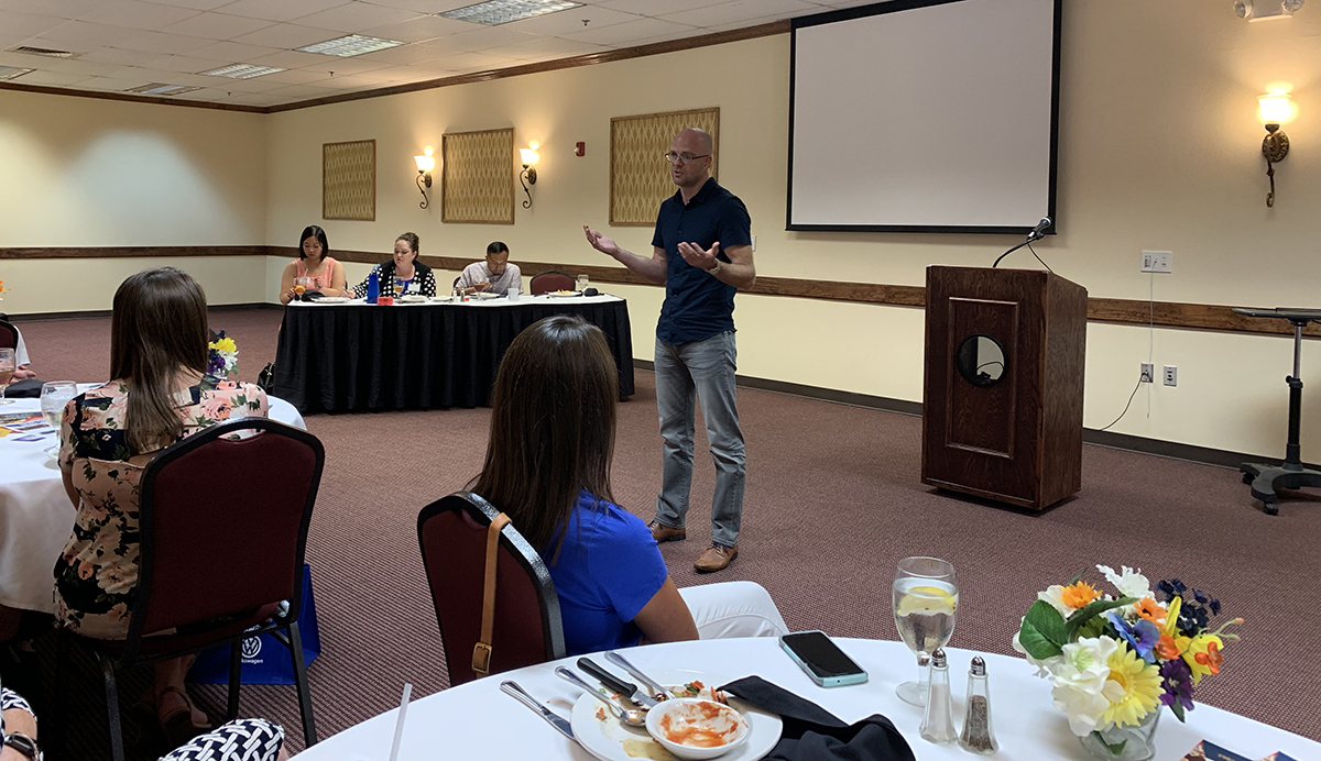 Andy Roller speaking in front of an audience.